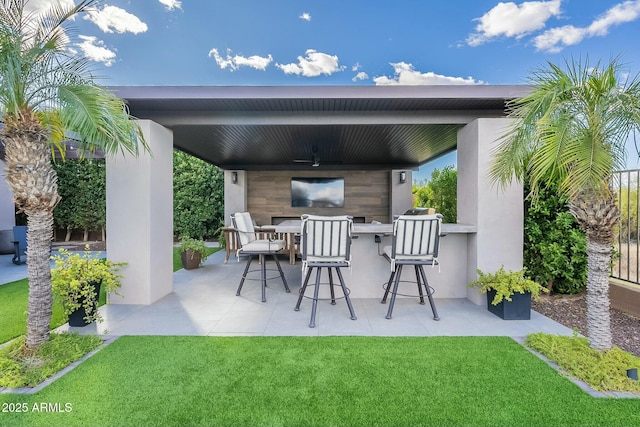 view of patio / terrace with ceiling fan and an outdoor bar