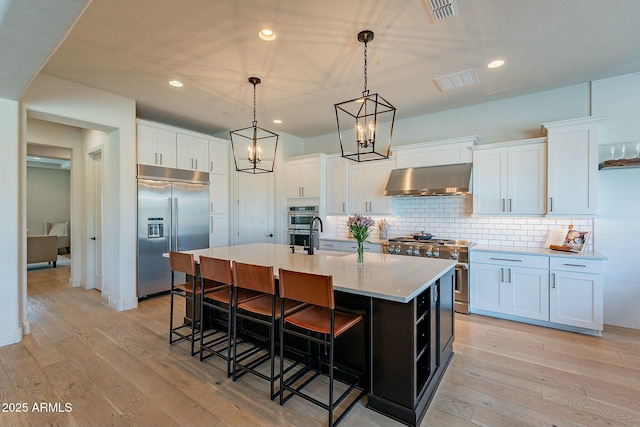 kitchen with white cabinets, extractor fan, and high end appliances