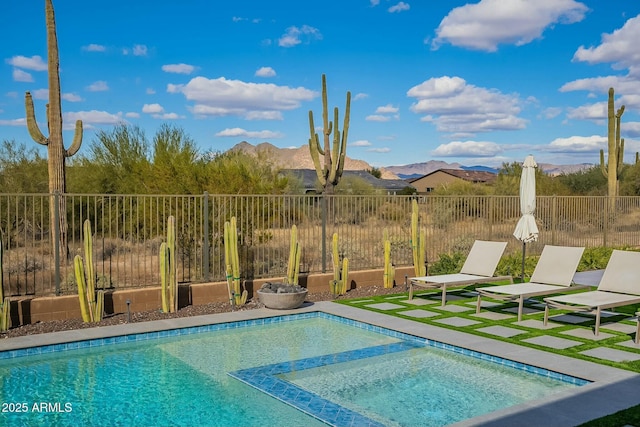 view of swimming pool featuring a mountain view and an in ground hot tub