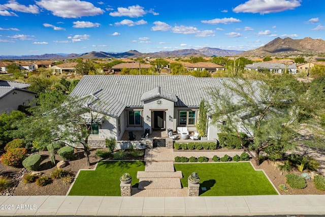 view of front facade featuring a mountain view and a front lawn