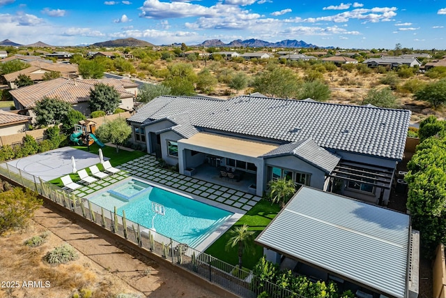 view of swimming pool featuring a mountain view, a patio, and a playground