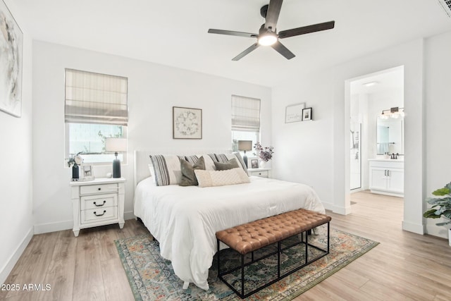 bedroom featuring ceiling fan, ensuite bathroom, and light wood-type flooring