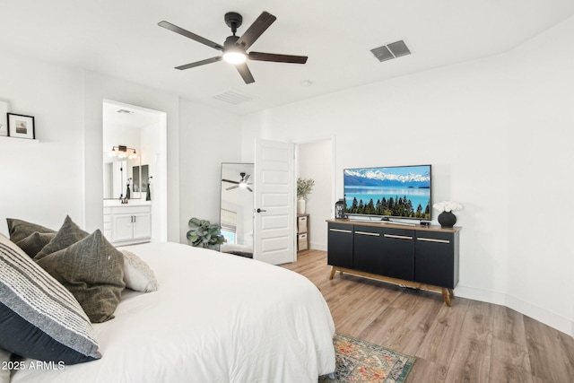 bedroom with ceiling fan, connected bathroom, and light hardwood / wood-style floors