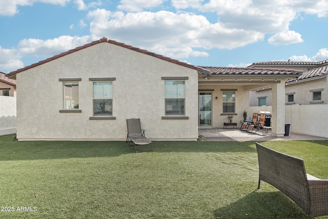 rear view of property with a yard and a patio area