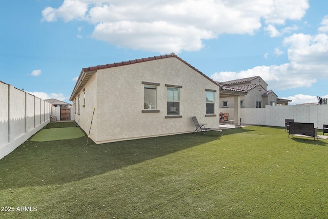 rear view of house featuring a yard and a patio area