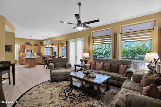 tiled living room featuring ceiling fan with notable chandelier