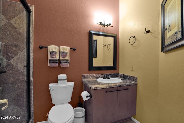 bathroom featuring vanity, toilet, and a shower with door