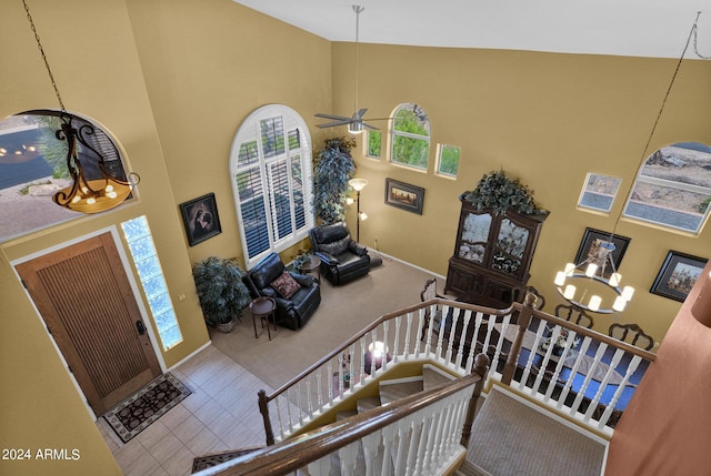 entrance foyer featuring high vaulted ceiling and ceiling fan with notable chandelier