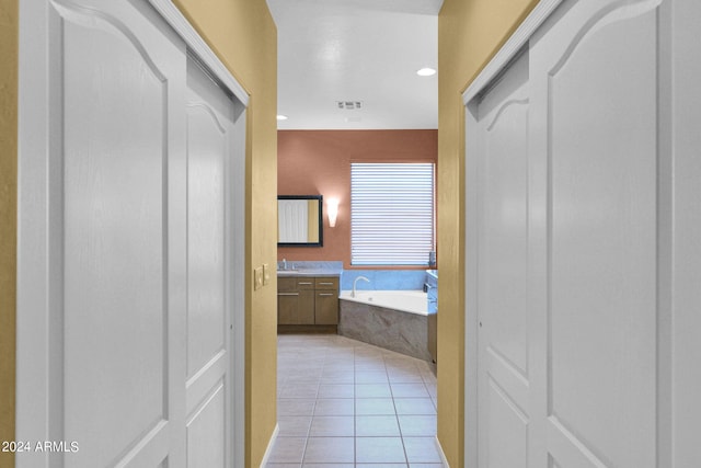 hall featuring sink and light tile patterned floors