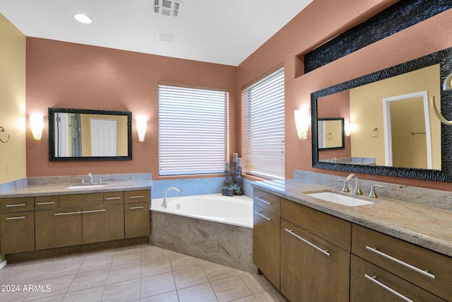 bathroom with vanity, tile patterned floors, and tiled tub