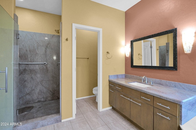 bathroom featuring toilet, vanity, tile patterned flooring, and walk in shower