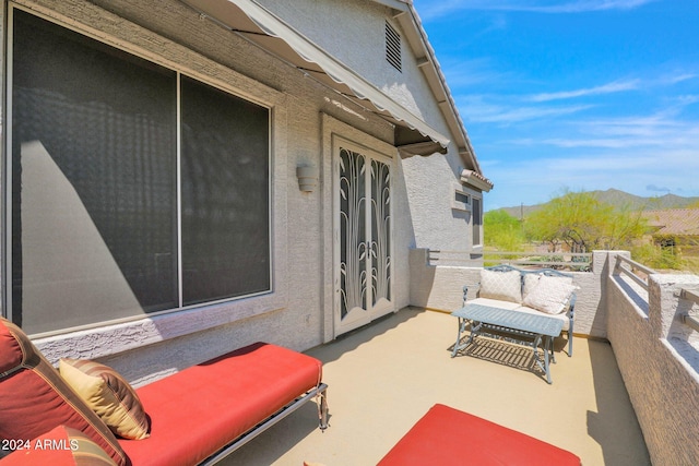 view of patio / terrace with a mountain view, french doors, and a balcony