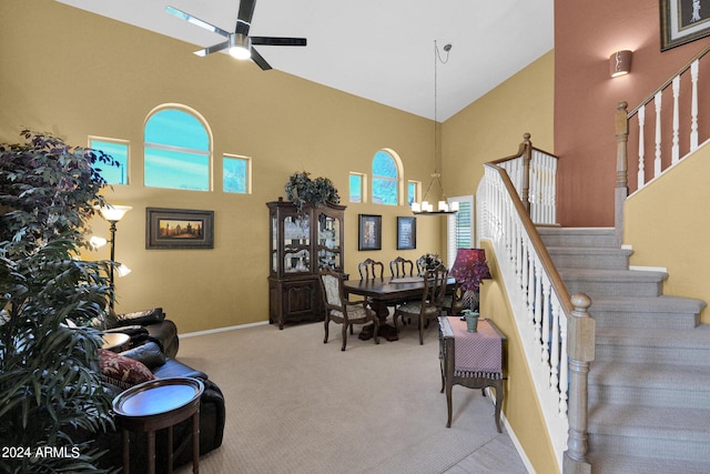 living room featuring ceiling fan with notable chandelier, light colored carpet, a healthy amount of sunlight, and high vaulted ceiling