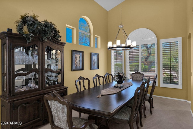 carpeted dining space with high vaulted ceiling and a notable chandelier