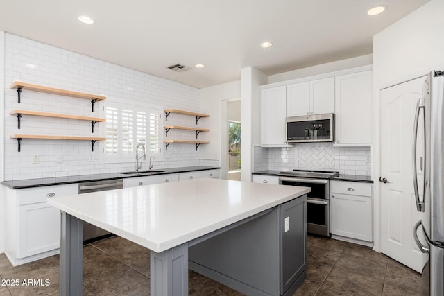 kitchen featuring backsplash, open shelves, visible vents, appliances with stainless steel finishes, and a sink