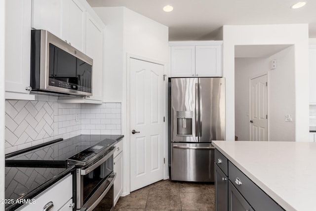 kitchen featuring decorative backsplash, white cabinets, and stainless steel appliances