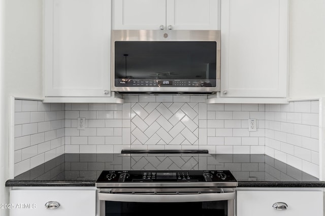 kitchen with range, decorative backsplash, stainless steel microwave, and white cabinetry