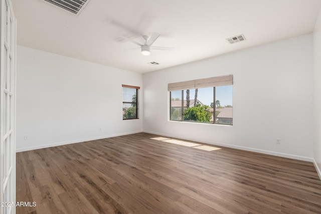 spare room featuring visible vents, baseboards, ceiling fan, and wood finished floors