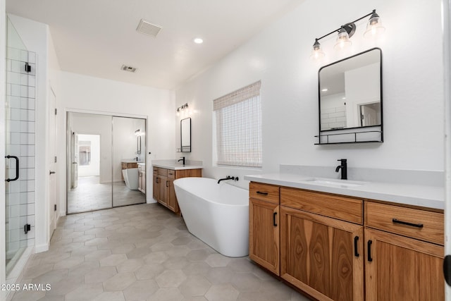 full bathroom featuring a shower stall, visible vents, a sink, and a freestanding bath
