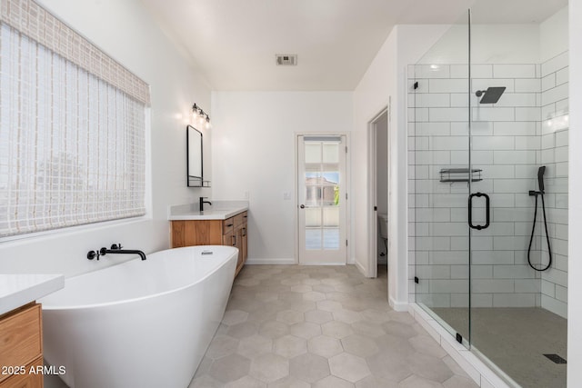 bathroom with a soaking tub, vanity, tile patterned flooring, visible vents, and a stall shower