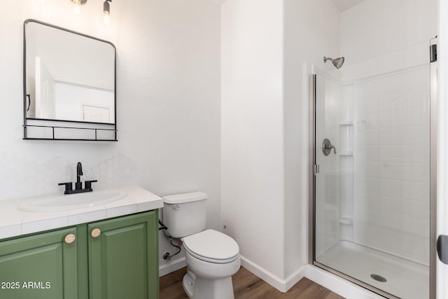 full bath with toilet, a stall shower, and wood finished floors