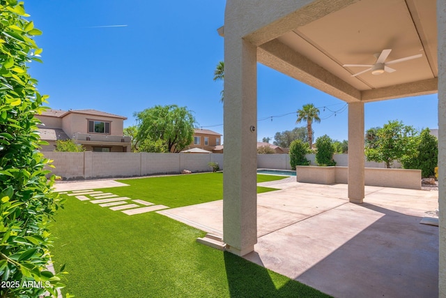 view of yard featuring a patio area, a fenced backyard, and ceiling fan