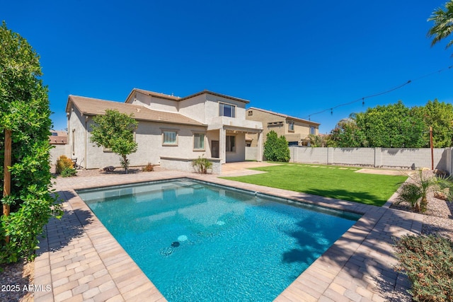 view of pool with a patio, a yard, and a fenced backyard