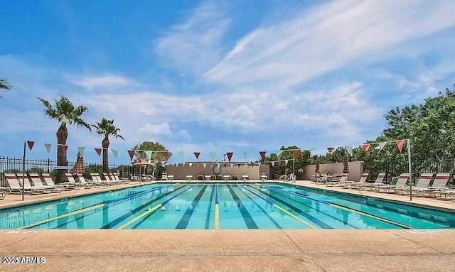 community pool with fence and a patio