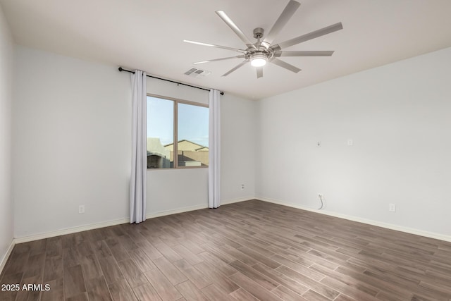 unfurnished room featuring a ceiling fan, visible vents, baseboards, and wood finished floors