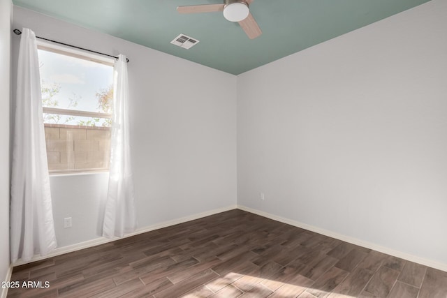 unfurnished room with a ceiling fan, visible vents, baseboards, and wood finished floors