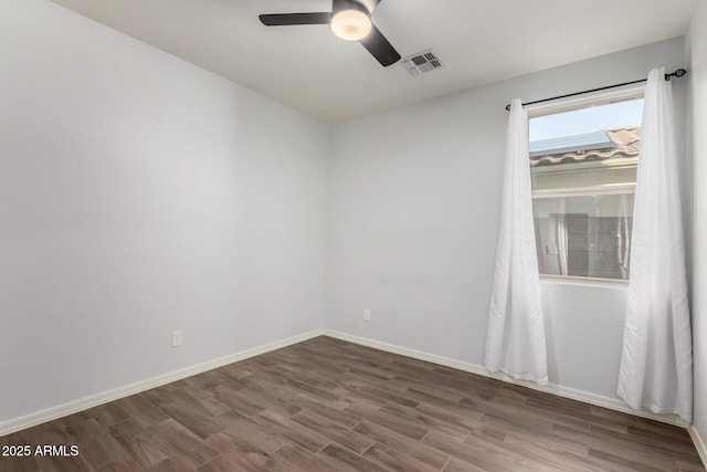 empty room featuring baseboards, visible vents, ceiling fan, and wood finished floors