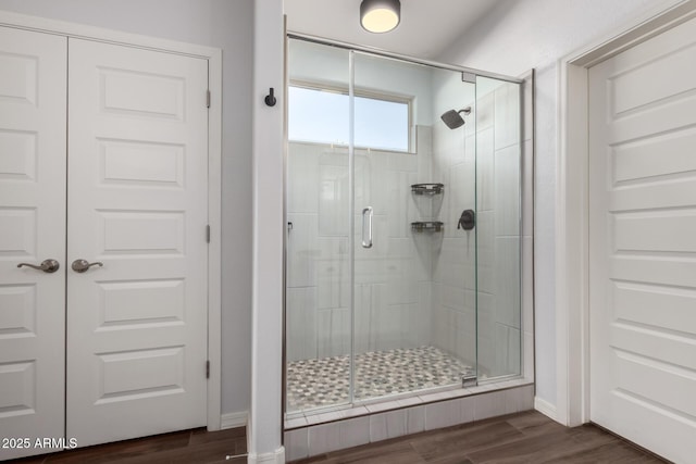 full bath featuring wood finished floors and a shower stall