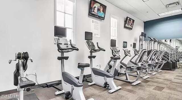 exercise room with carpet flooring, visible vents, and baseboards