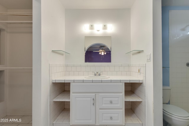 full bathroom featuring tile patterned floors, toilet, decorative backsplash, ceiling fan, and vanity