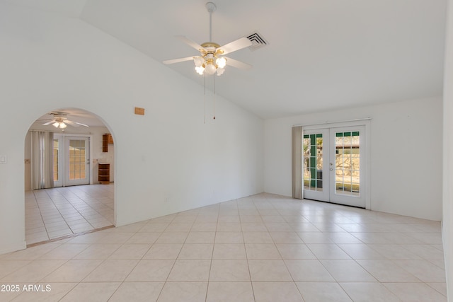 unfurnished room with light tile patterned floors, visible vents, arched walkways, ceiling fan, and french doors