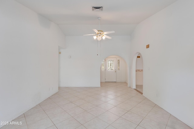 unfurnished room featuring visible vents, high vaulted ceiling, arched walkways, light tile patterned floors, and ceiling fan