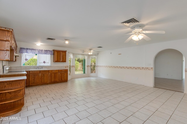 kitchen featuring open shelves, open floor plan, visible vents, and ceiling fan