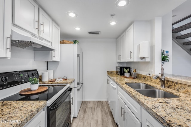 kitchen with light stone counters, under cabinet range hood, electric range, a sink, and white cabinets