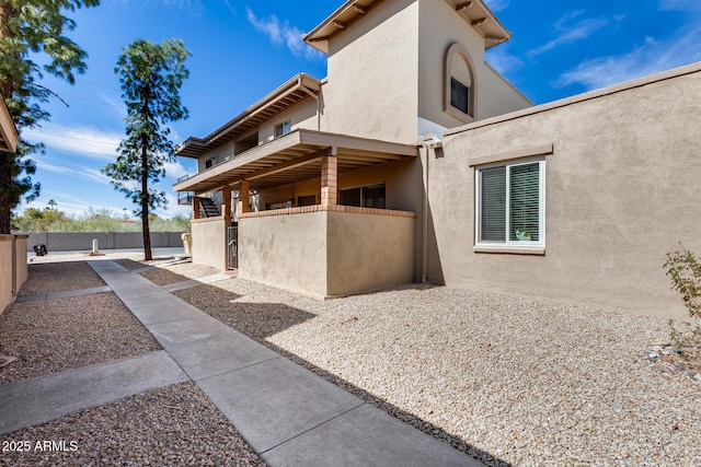 view of property exterior with fence and stucco siding