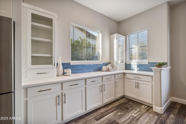 kitchen featuring white cabinets, decorative backsplash, stainless steel fridge, and dark wood-type flooring