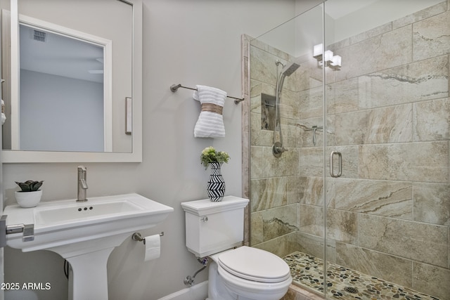 bathroom featuring sink, an enclosed shower, and toilet