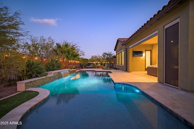 view of swimming pool with pool water feature and a patio