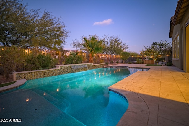 pool at dusk with a patio