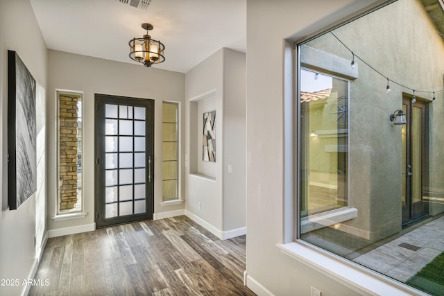 foyer featuring dark hardwood / wood-style flooring and an inviting chandelier