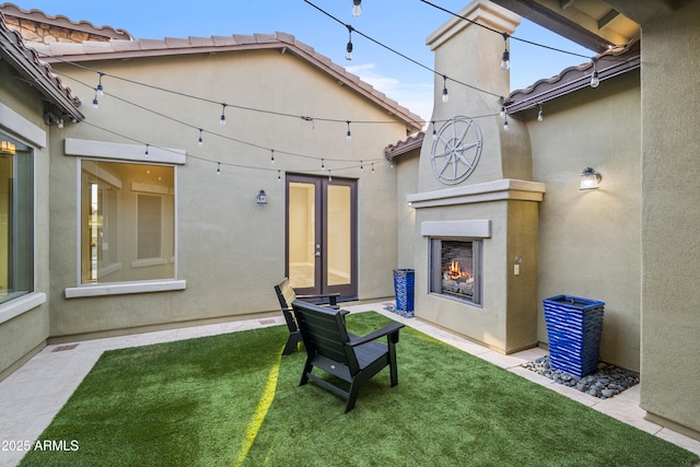 exterior space with french doors and exterior fireplace