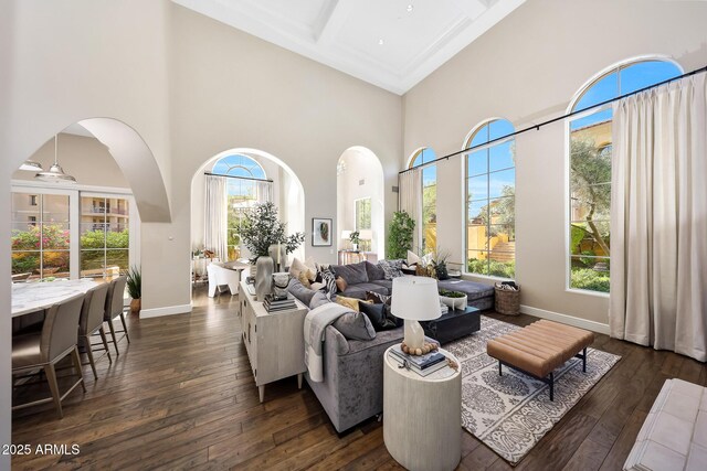 18927 N 101st St, Scottsdale, AZ 85255 - living room with a towering ceiling, dark wood-style flooring, baseboards, beamed ceiling, and arched walkways