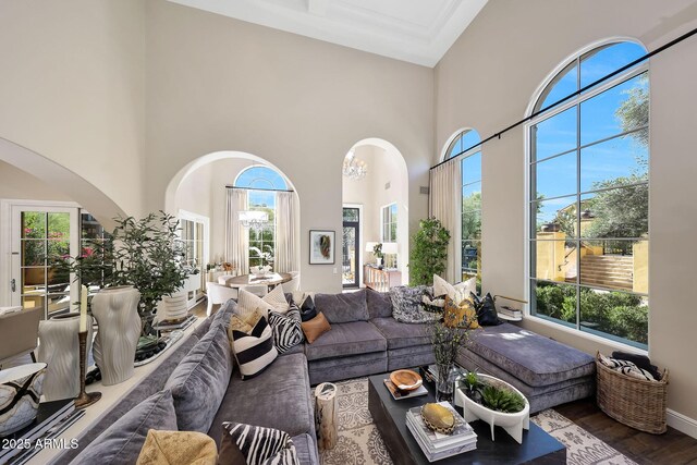 18927 N 101st St, Scottsdale, AZ 85255 - living room featuring arched walkways, plenty of natural light, a towering ceiling, and wood finished floors