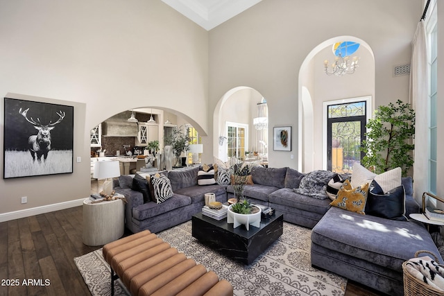 18927 N 101st St, Scottsdale, AZ 85255 - living area with arched walkways, a chandelier, wood-type flooring, a towering ceiling, and baseboards