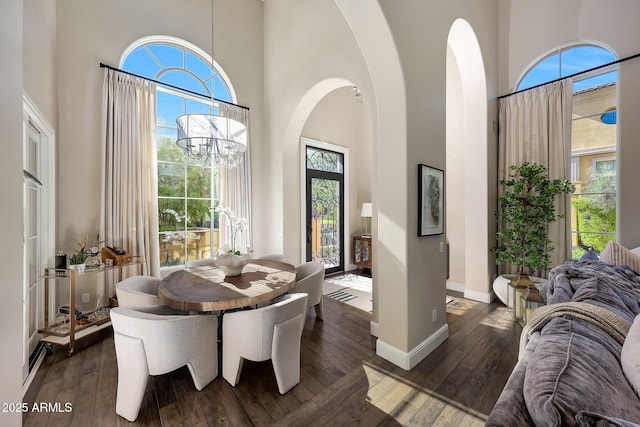18927 N 101st St, Scottsdale, AZ 85255 - dining room featuring a high ceiling, dark wood-style floors, baseboards, arched walkways, and a chandelier