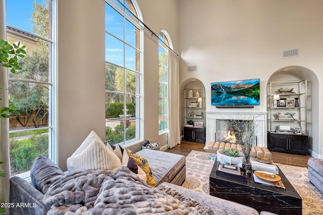 18927 N 101st St, Scottsdale, AZ 85255 - living area with a high end fireplace, wood finished floors, built in shelves, baseboards, and a high ceiling